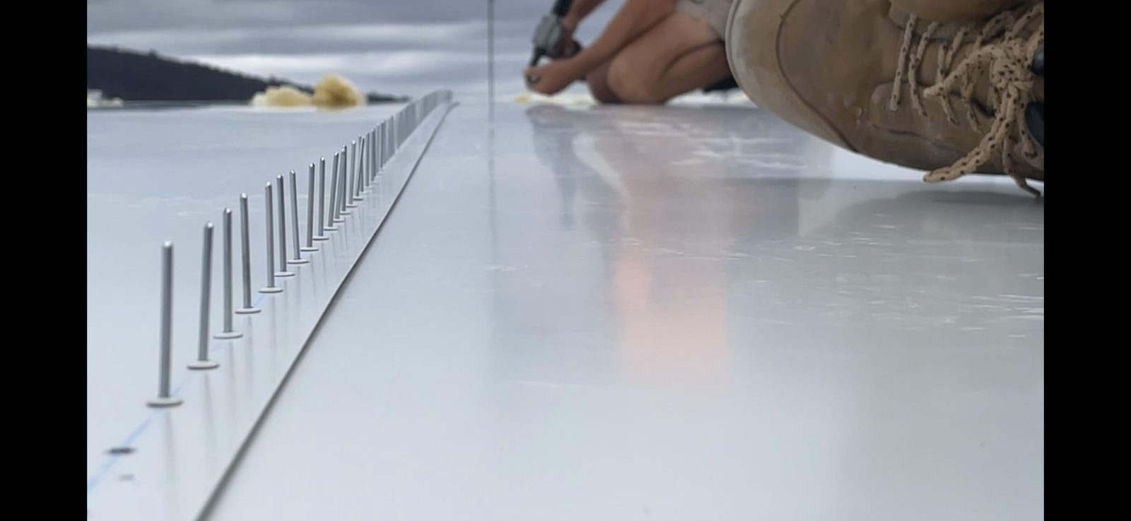 Roofer installing metal roof panels